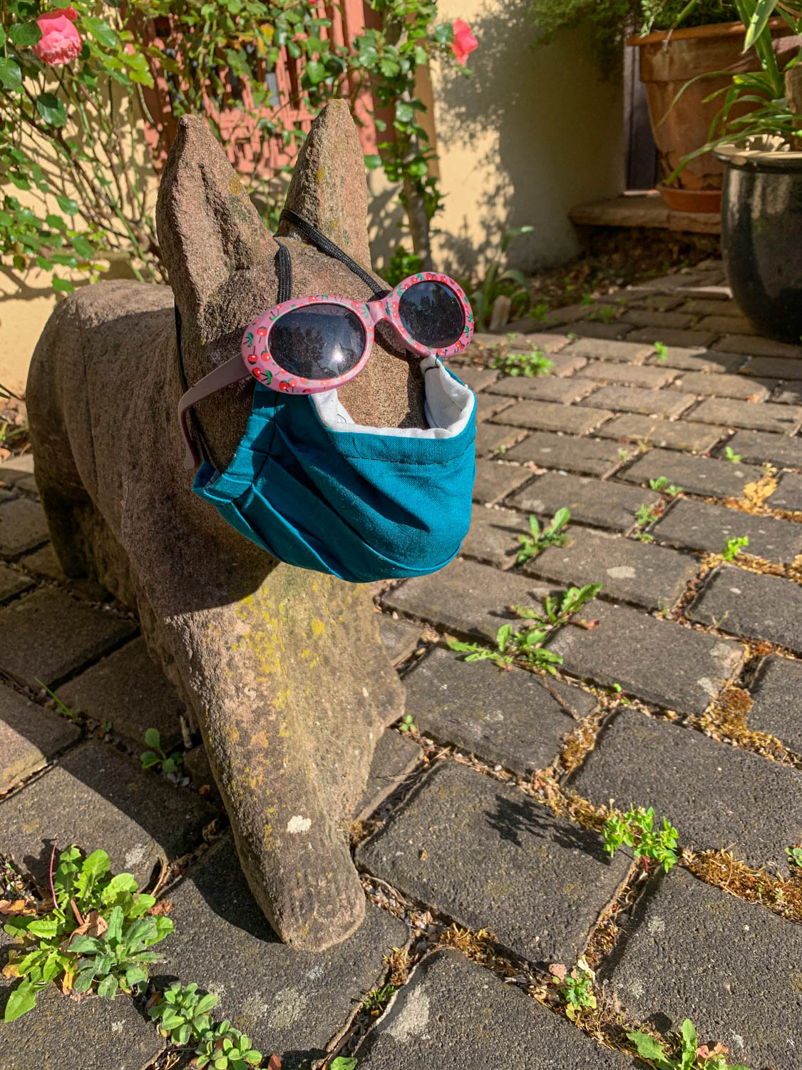 Steinerner Fuchs mit Coronamaske und Sonnenbrille